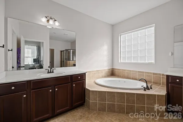 a spacious bathroom with a tub sink and mirror