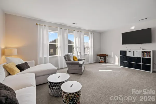a living room with furniture a flat screen tv and a window