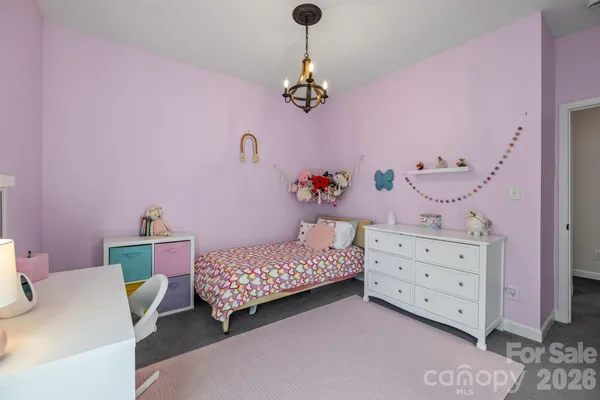 a bedroom with a bed and chandelier