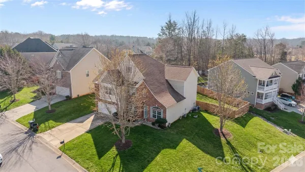 a aerial view of a house with a big yard and large trees