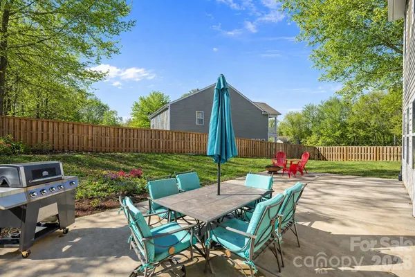 a view of a chairs and table in the back yard of the house