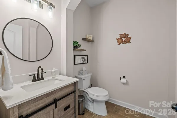 a bathroom with a toilet a sink and mirror