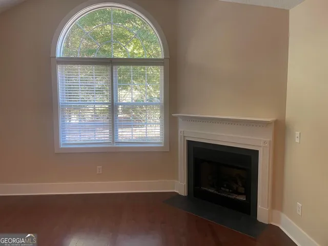 an empty room with a fireplace and windows