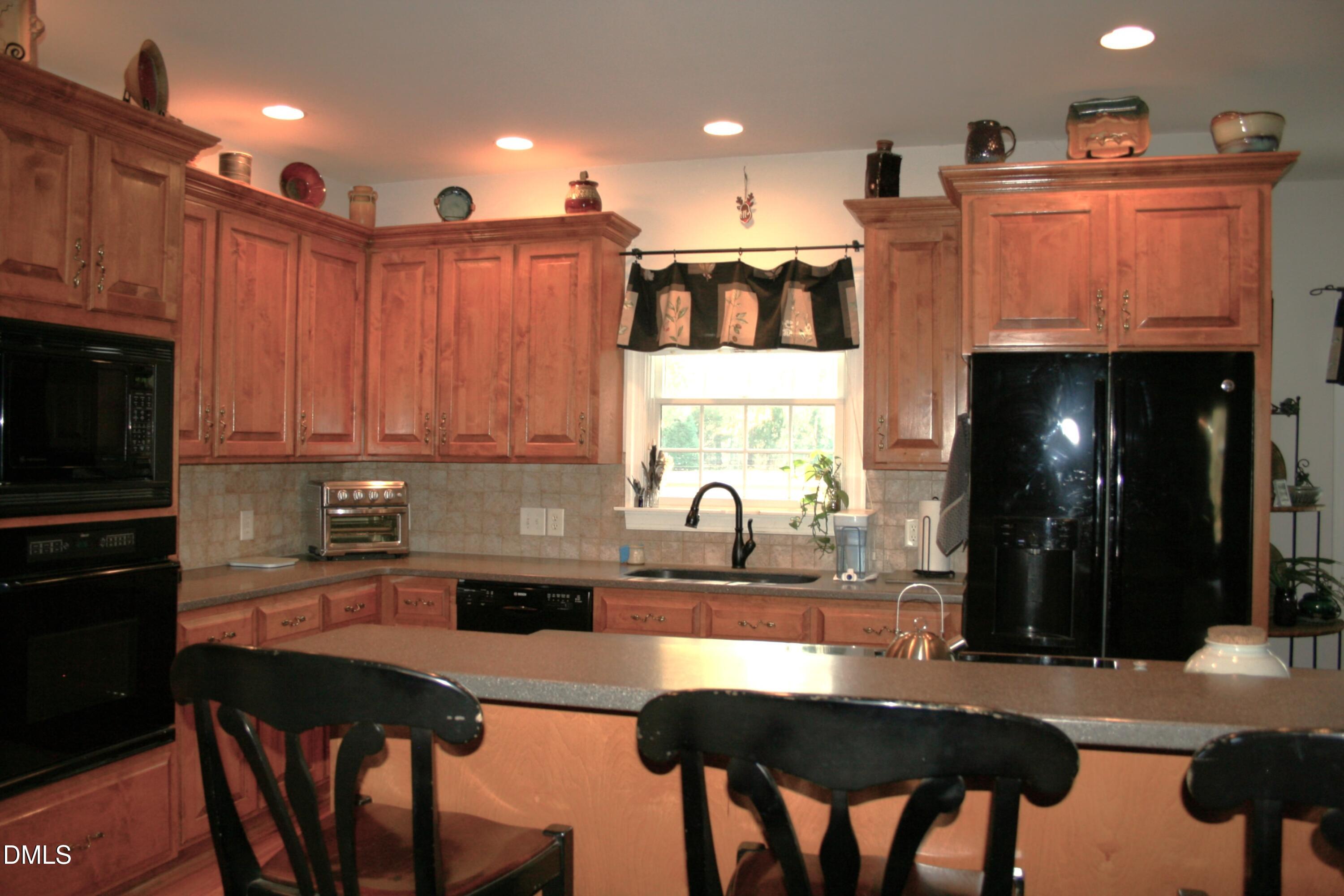 220 Jordan Narron Road Selma, NC 27576 - Photo 20 of 87 a kitchen with stainless steel appliances granite countertop a table chairs sink and cabinets