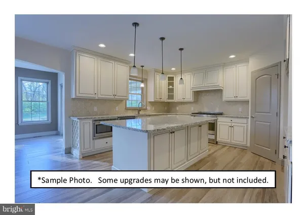 a kitchen with kitchen island stainless steel appliances a sink refrigerator and cabinets