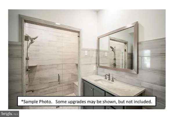 a bathroom with a sink a mirror and a glass door shower