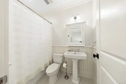 a bathroom with a sink toilet and mirror