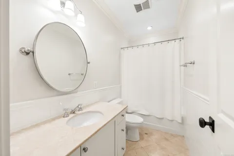 a bathroom with a granite countertop sink mirror vanity and toilet