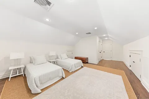 a spacious bedroom with two bed and a lamp