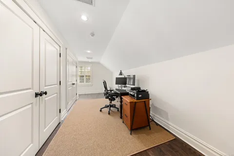 a view of a workspace with furniture and a window