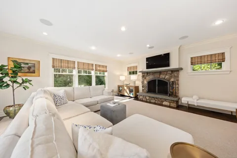 a living room with furniture a large window and a fireplace
