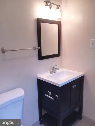 a bathroom with a sink vanity and a toilet