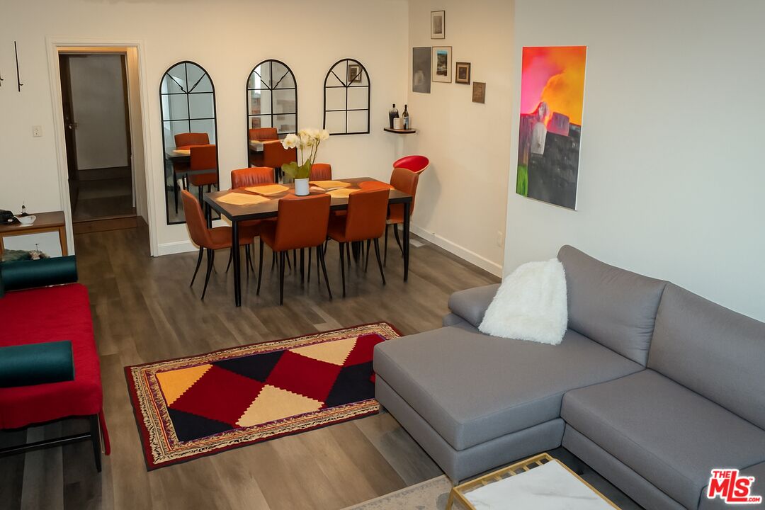 11670 Sunset Boulevard, Unit 104 Los Angeles, CA 90049 - Photo 4 of 11 a living room with furniture a rug and white walls