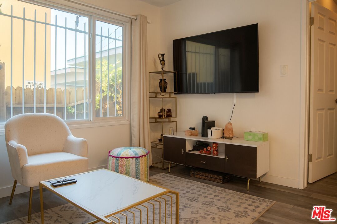 11670 Sunset Boulevard, Unit 104 Los Angeles, CA 90049 - Photo 5 of 11 a living room with furniture and a window
