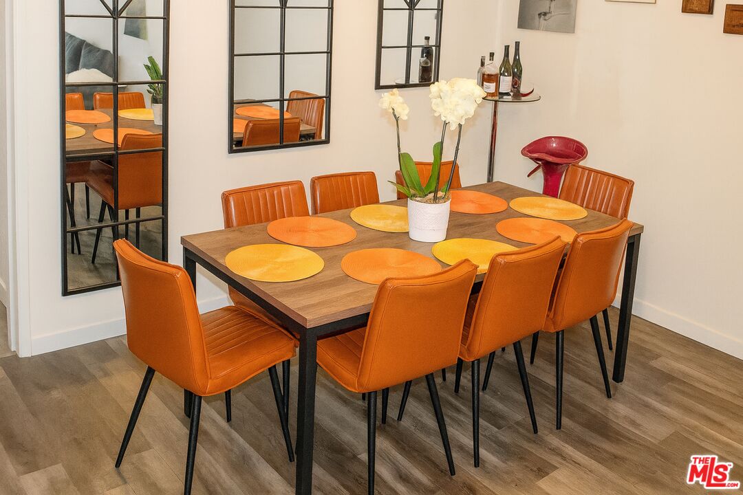 11670 Sunset Boulevard, Unit 104 Los Angeles, CA 90049 - Photo 7 of 11 a dining room with furniture and wooden floor