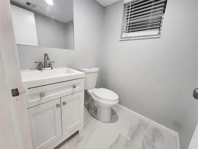 a white toilet sitting next to a bathroom sink