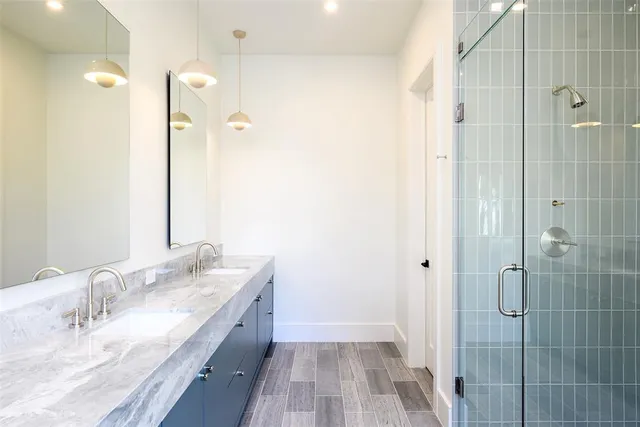 a bathroom with a granite countertop sink a shower and a mirror