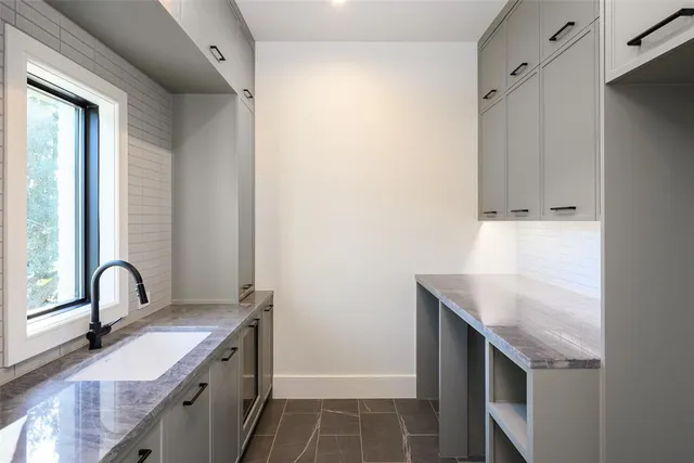 a kitchen with granite countertop a sink and a stove