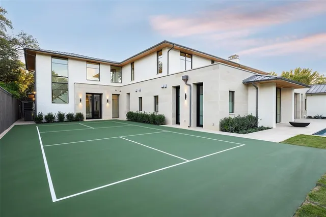 a view of a white house with a big yard and plants