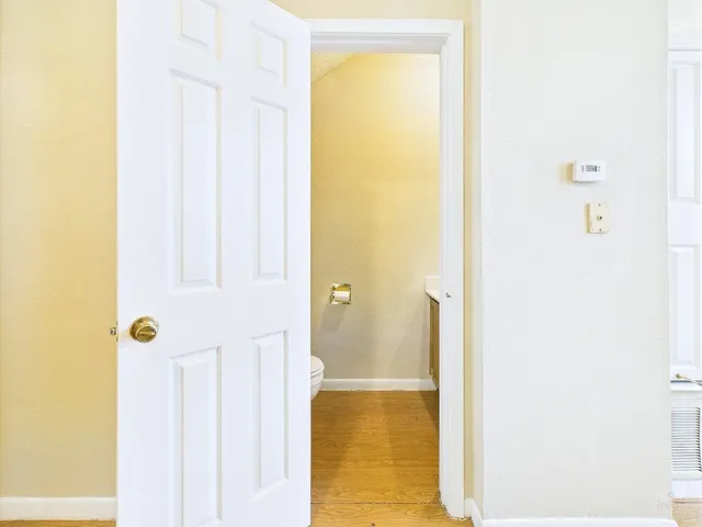 a white toilet sitting next to a white wall
