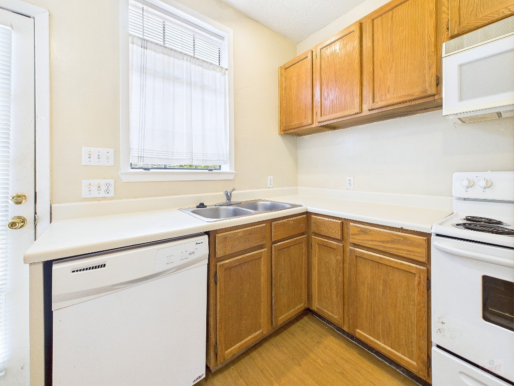 2300 Leon Street, Unit 204 Austin, TX 78705 - Photo 6 of 31 a kitchen with a sink cabinets appliances and a window
