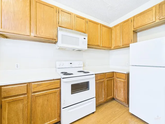 a kitchen with stainless steel appliances white cabinets and a refrigerator