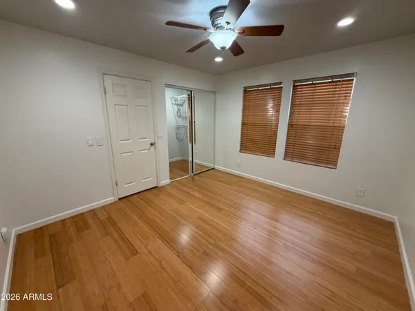 a view of an empty room with a window and wooden floor