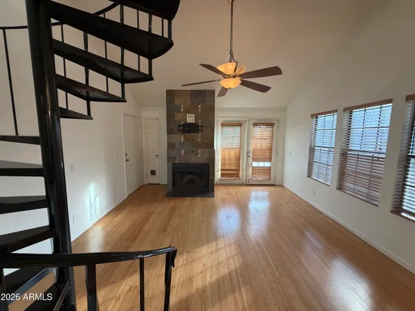 a view of an empty room with a window and wooden floor