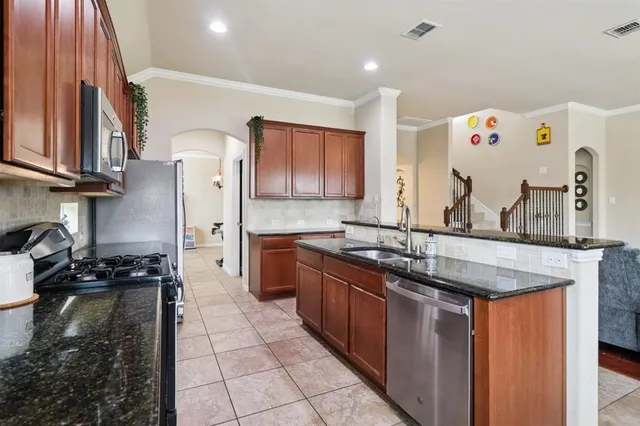 a kitchen with stainless steel appliances granite countertop a sink stove and refrigerator