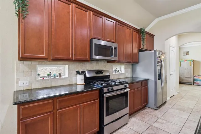 a kitchen with granite countertop wooden cabinets and stainless steel appliances