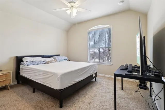 a bed sitting in a bedroom next to a window