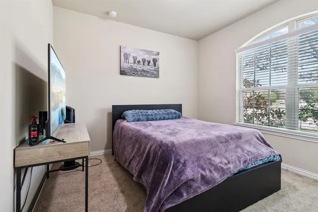 a bedroom with a bed and a flat screen tv