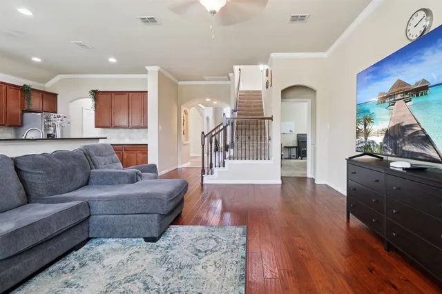 a living room with furniture and a wooden floor