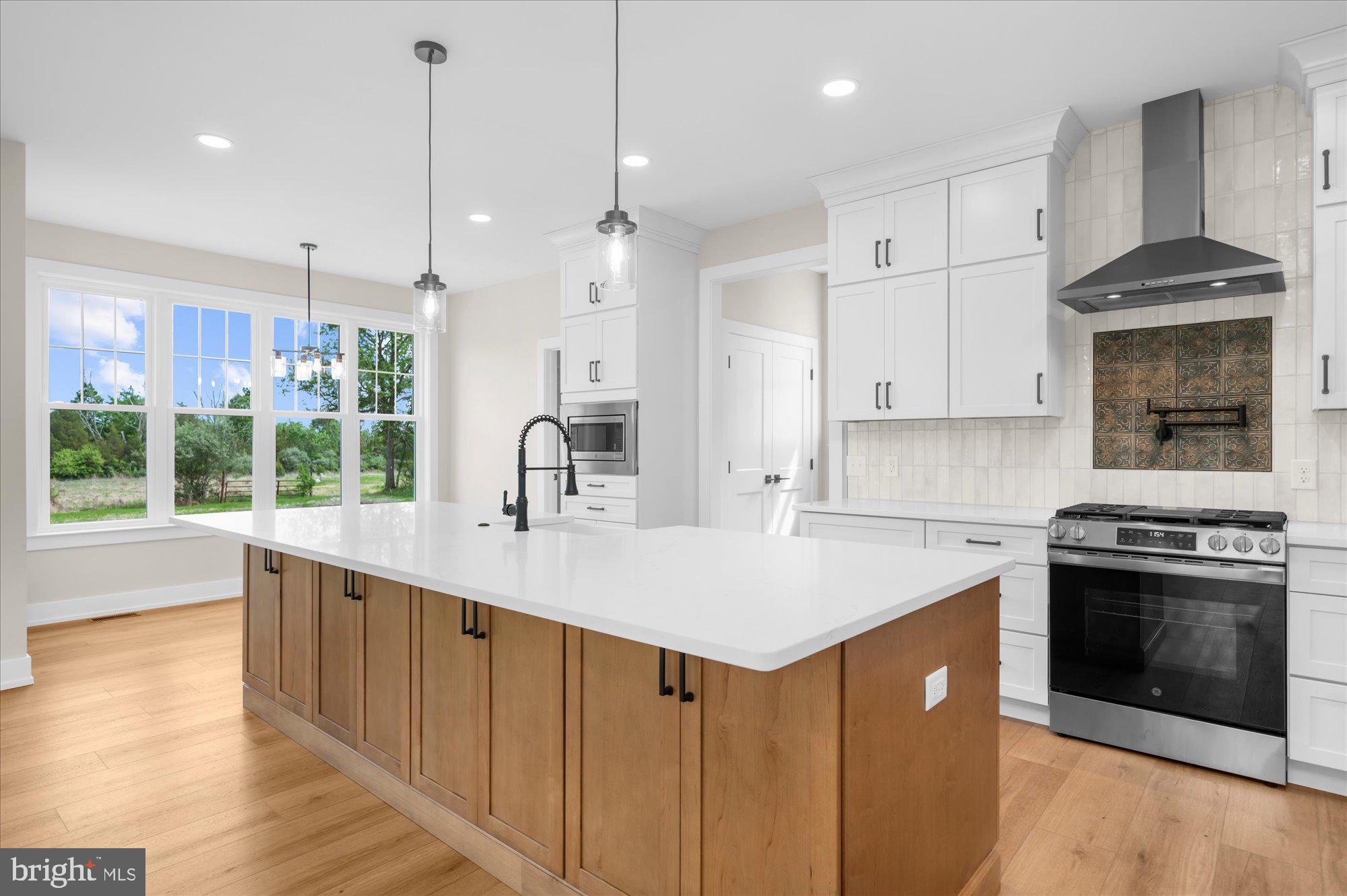 394 Renninger Road Perkiomenville, PA 18074 - Photo 19 of 41 a kitchen with stainless steel appliances granite countertop a stove a sink and a refrigerator with wooden floor