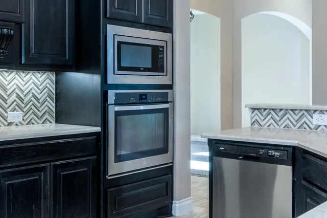 a kitchen with granite countertop cabinets stainless steel appliances and counter space