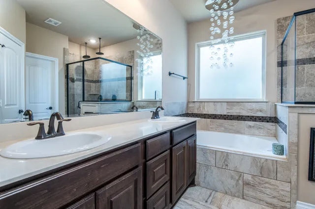 a bathroom with a granite countertop bathtub sink vanity and mirror