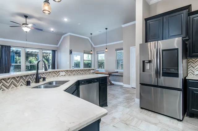 a kitchen with stainless steel appliances granite countertop a sink a stove and a refrigerator
