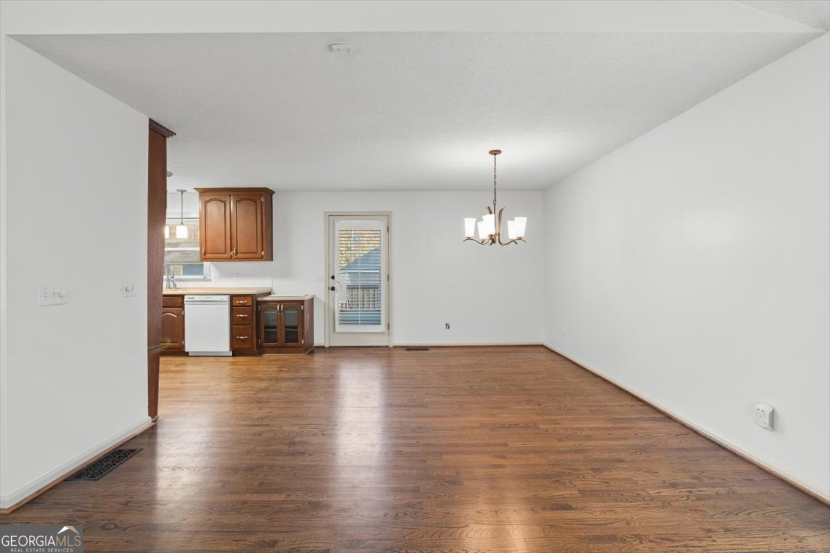 325 Almon Road Carrollton, GA 30117 - Photo 11 of 41 wooden floor in an empty room with a kitchen