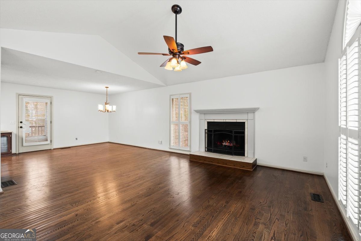 325 Almon Road Carrollton, GA 30117 - Photo 5 of 41 an empty room with wooden floor chandelier fan and windows