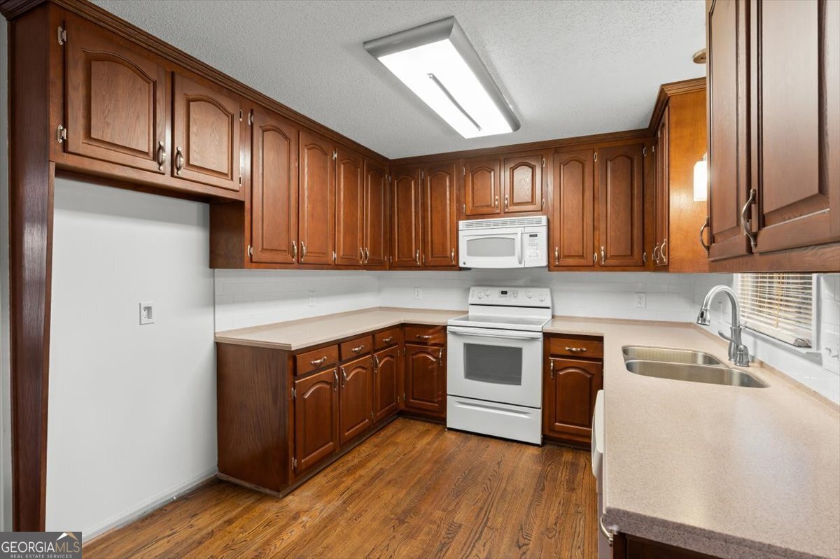 325 Almon Road Carrollton, GA 30117 - Photo 9 of 41 a kitchen with stainless steel appliances granite countertop wooden cabinets a stove top oven a sink and dishwasher with wooden floor