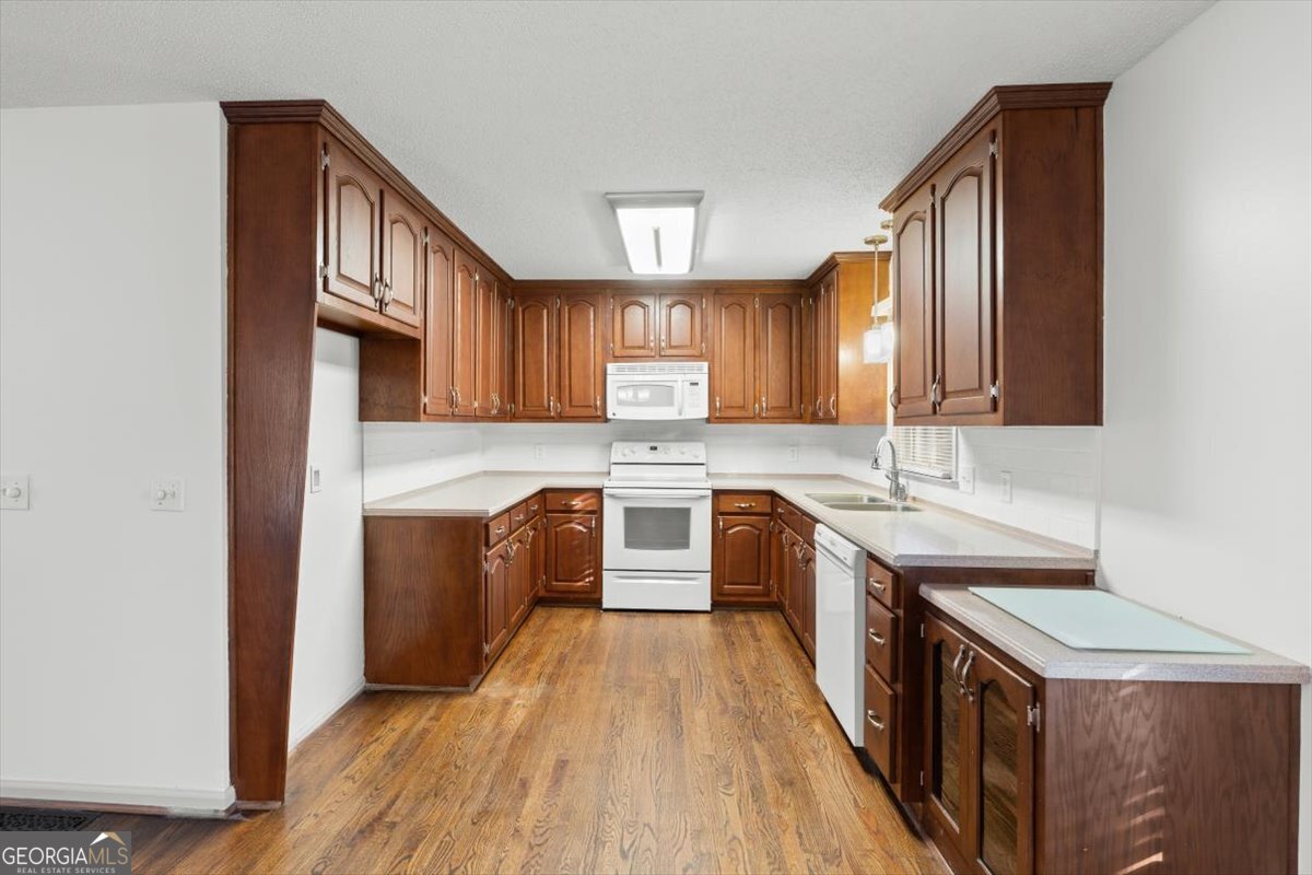 325 Almon Road Carrollton, GA 30117 - Photo 10 of 41 a kitchen with a sink stove top oven and wooden floor