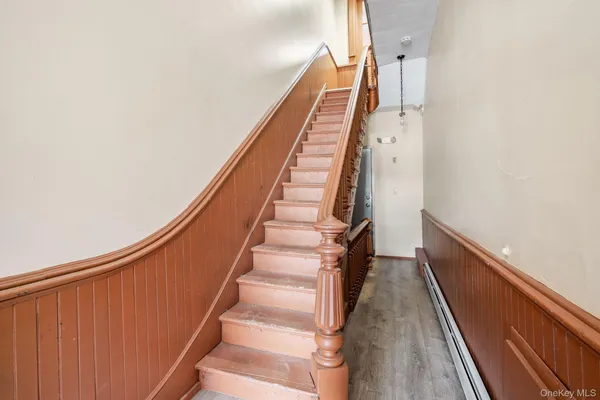a view of staircase with wooden floor and white walls