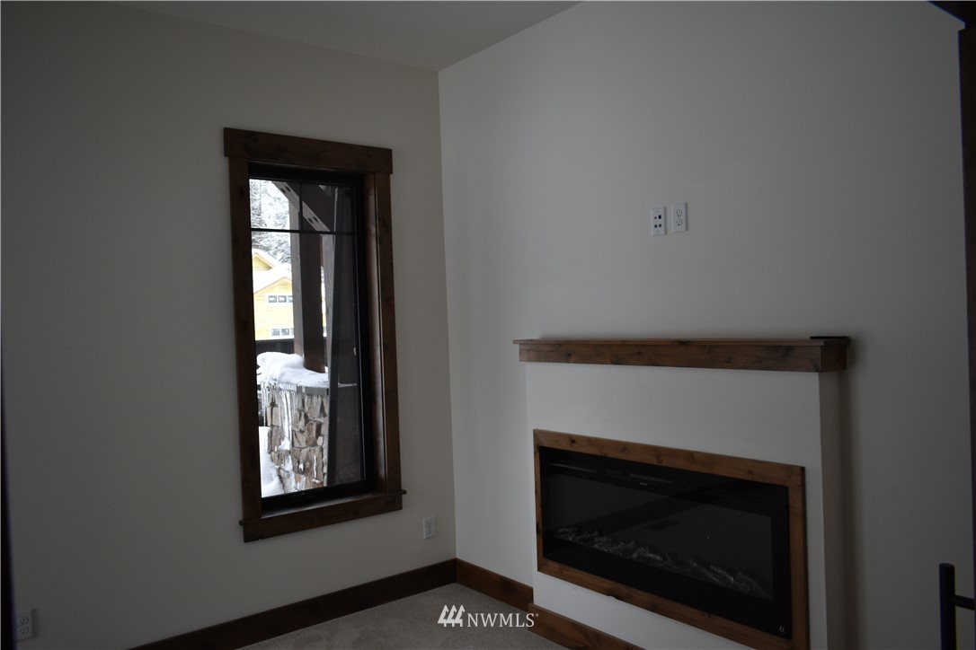 1421 Kokanee Loop Cle Elum, WA 98922 - Photo 21 of 33 a living room with a fireplace and a window