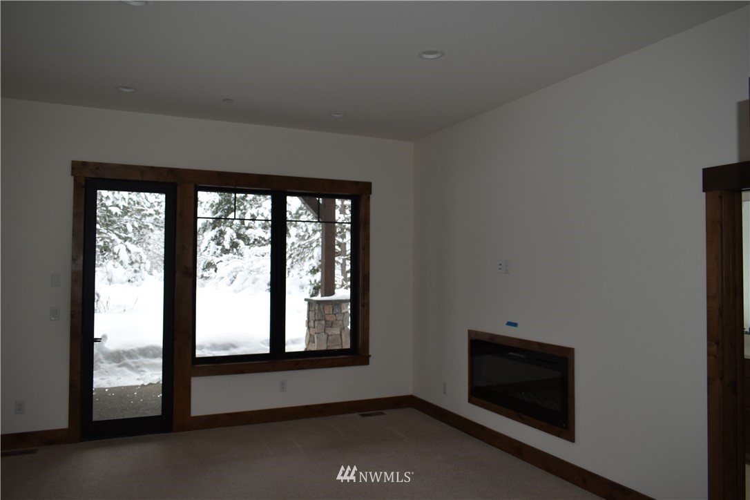 1421 Kokanee Loop Cle Elum, WA 98922 - Photo 23 of 33 a room with a fireplace and a floor to ceiling window