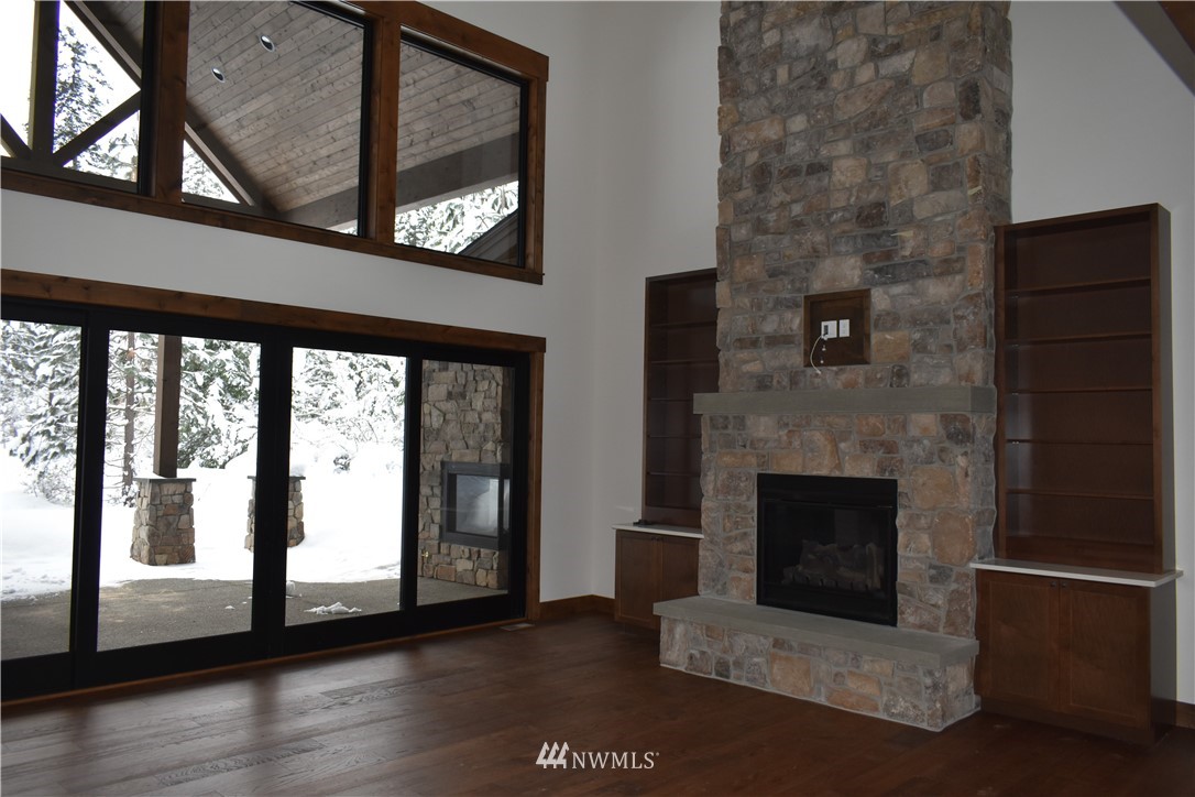1421 Kokanee Loop Cle Elum, WA 98922 - Photo 5 of 33 a living room with a fireplace and a floor to ceiling window