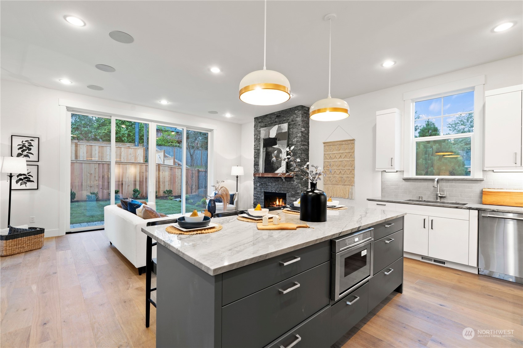 10063 Dibble Avenue Northwest Seattle, WA 98177 - Photo 1 of 35 a kitchen with a stove a sink dishwasher and a dining table with wooden floor