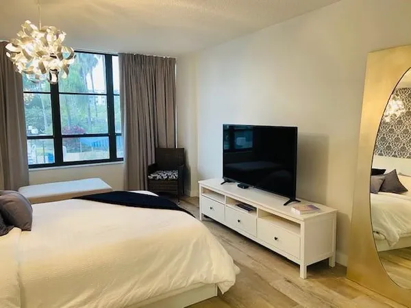a bedroom with a bed and a flat screen tv