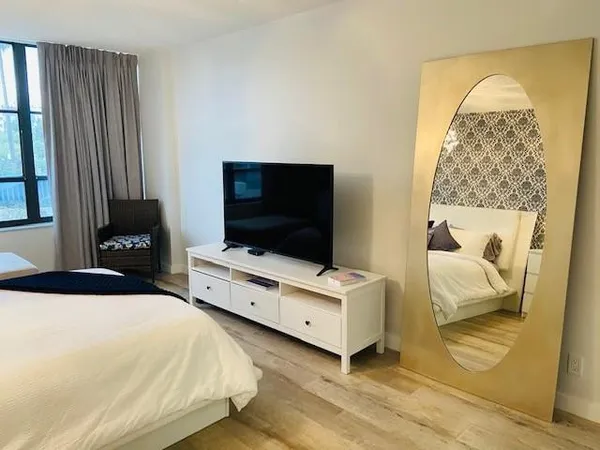 a bedroom with a bed and a flat tv screen on a dresser