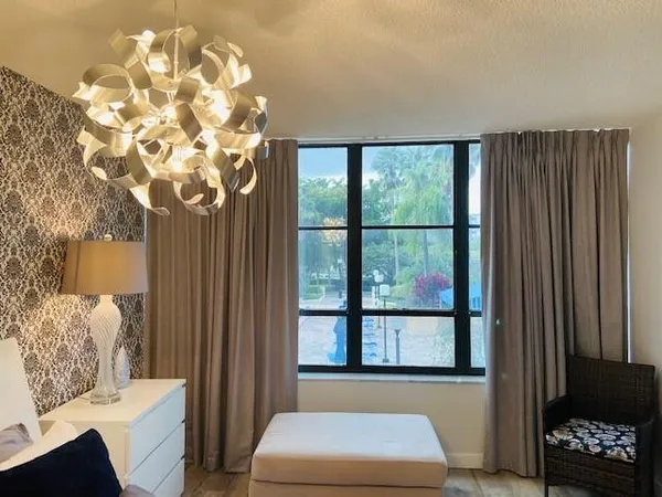 a living room with furniture a large window and flat screen tv