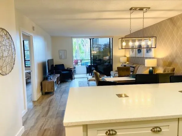 a kitchen with a sink a counter space and living room